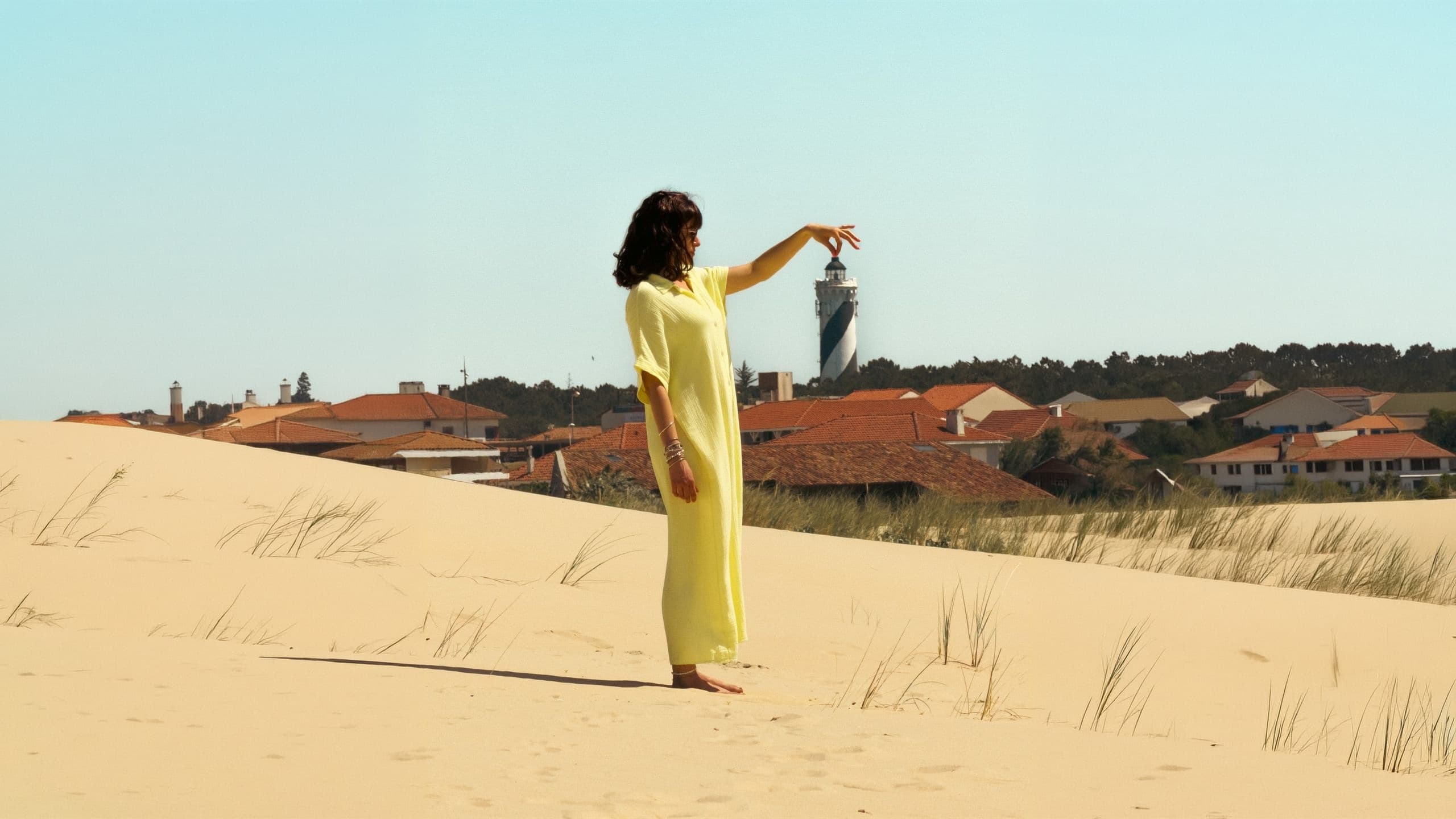 Femme en robe legere sur une plage au coucher de soleil